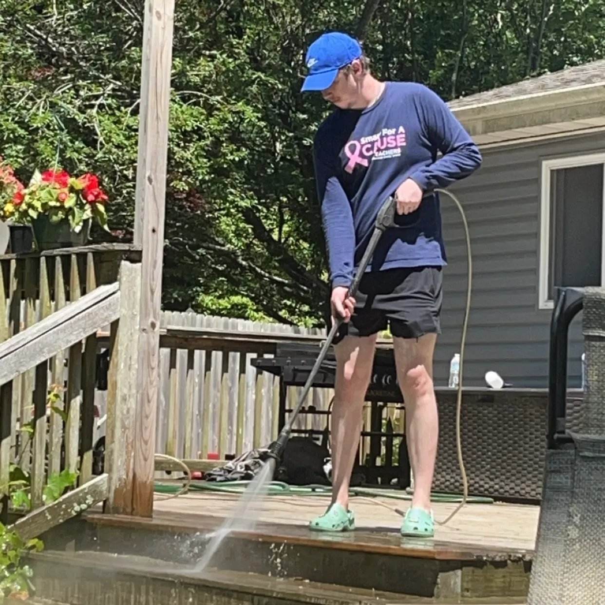 Dylan at a client site power washing a deck